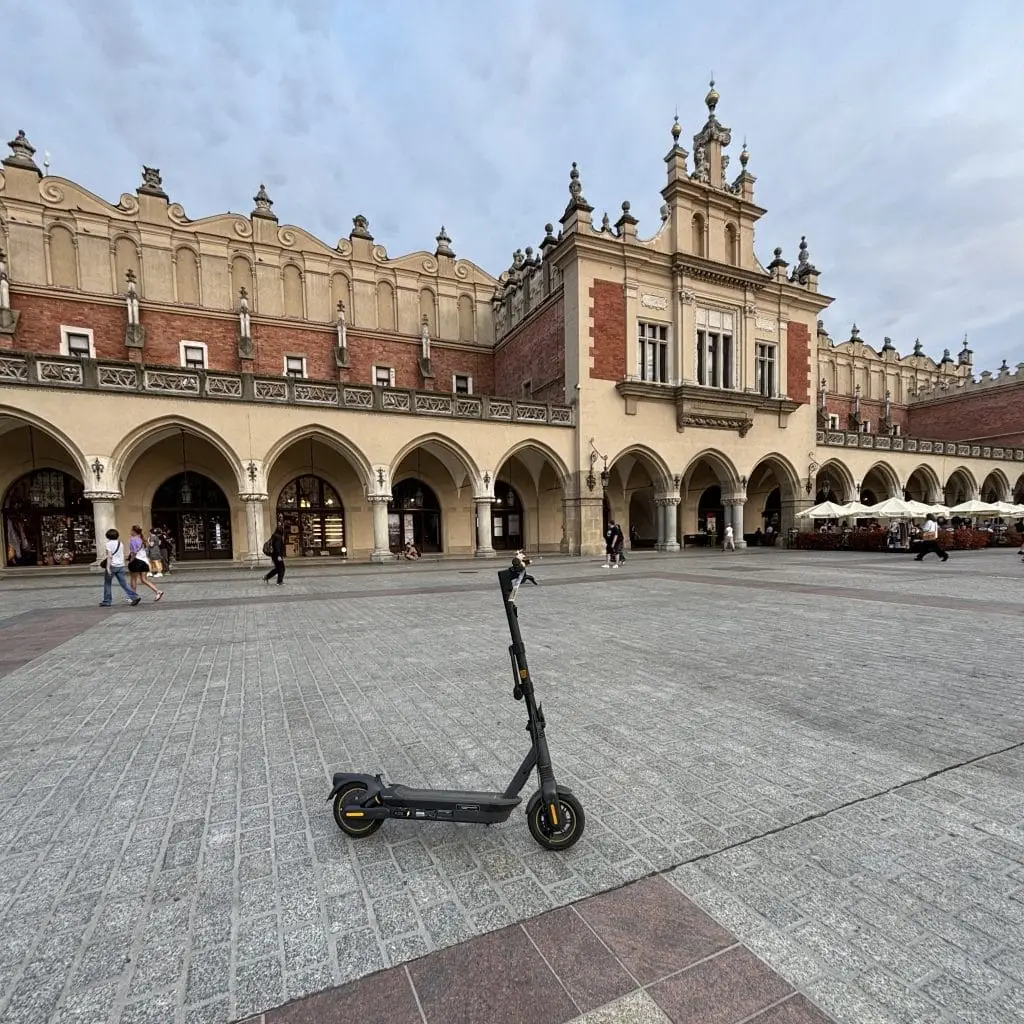 Scooter eléctrico aparcado en la Plaza del Mercado de Cracovia: una forma de visitar las atracciones de Cracovia.