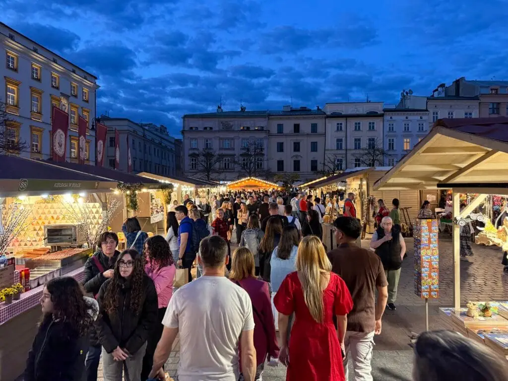 Ein abendlicher Bummel über den Ostermarkt 2025 auf dem Krakauer Hauptmarkt, beleuchtete Stände und eine festliche Atmosphäre.