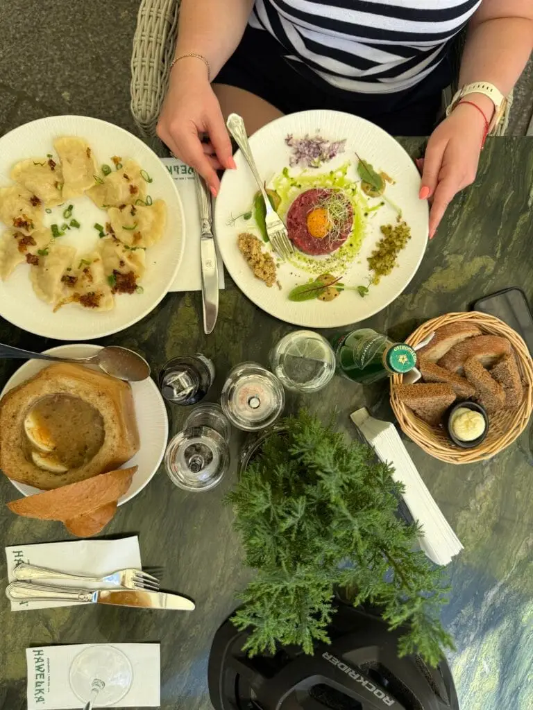 Tradycyjne dania w Restauracji Hawełka: pierogi, tatar wołowy z żółtkiem i żur w chlebie – stolik w ogródku letnim przy Rynku Głównym w Krakowie