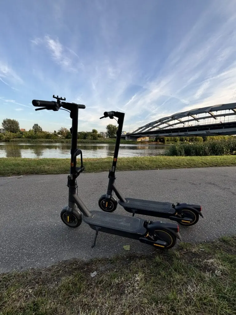 Two electric scooters parked against the backdrop of the Vistula River - City Glide in Krakow