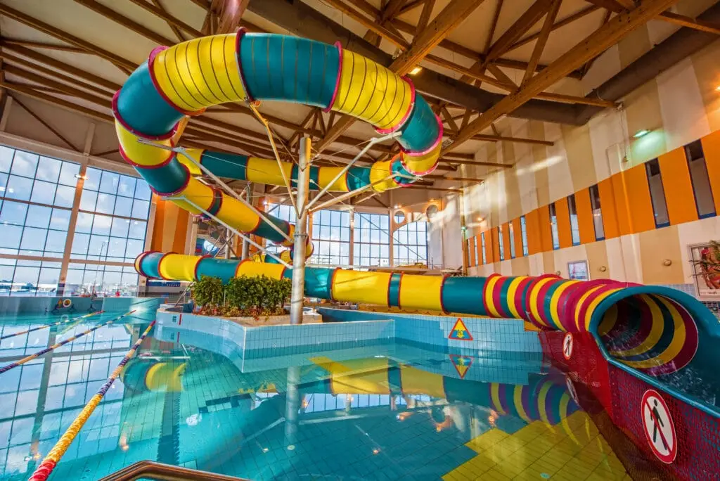 Tobogán amarillo turquesa en la sala de piscinas del Parque Acuático de Cracovia