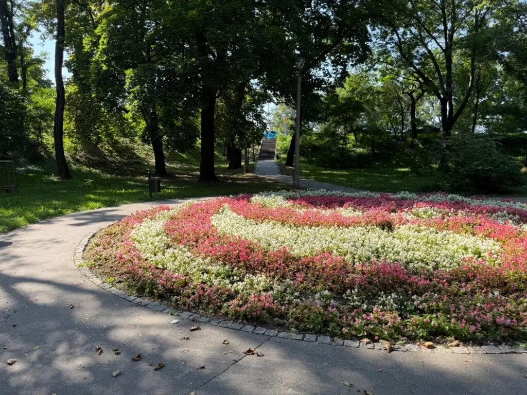 Parterre redondo con flores rosas y blancas en Planty Podgórze