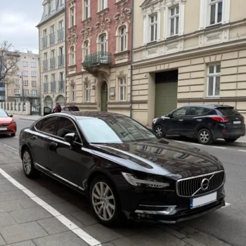 Schwarze Luxuslimousine Volvo S90 – Executive Chauffeur und VIP-Concierge-Service vor dem Gebäude.